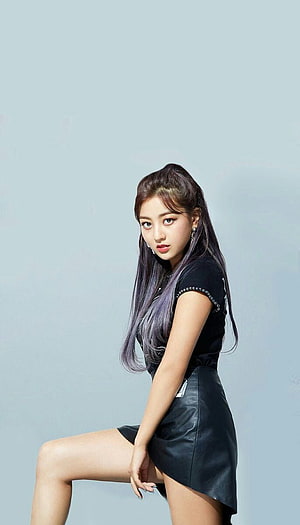 Nayeon from TWICE in a black leather skirt and studded top against a light blue studio backdrop HD phone wallpaper