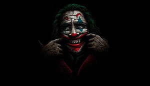 Joker Character Portrait with Clown Makeup and Red Suit in Dark Setting HD wallpaper