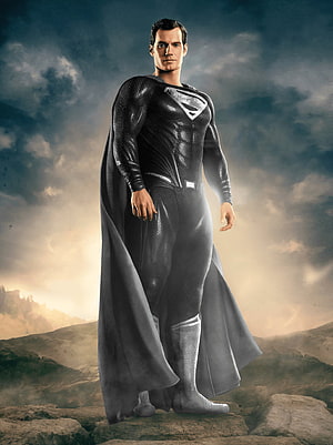 Superman in Black Suit Standing on Rocky Terrain Under Dramatic Sky HD phone wallpaper