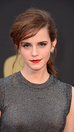 Emma Watson in a shimmering silver sleeveless top with elegant updo and red lipstick at a formal event HD phone wallpaper