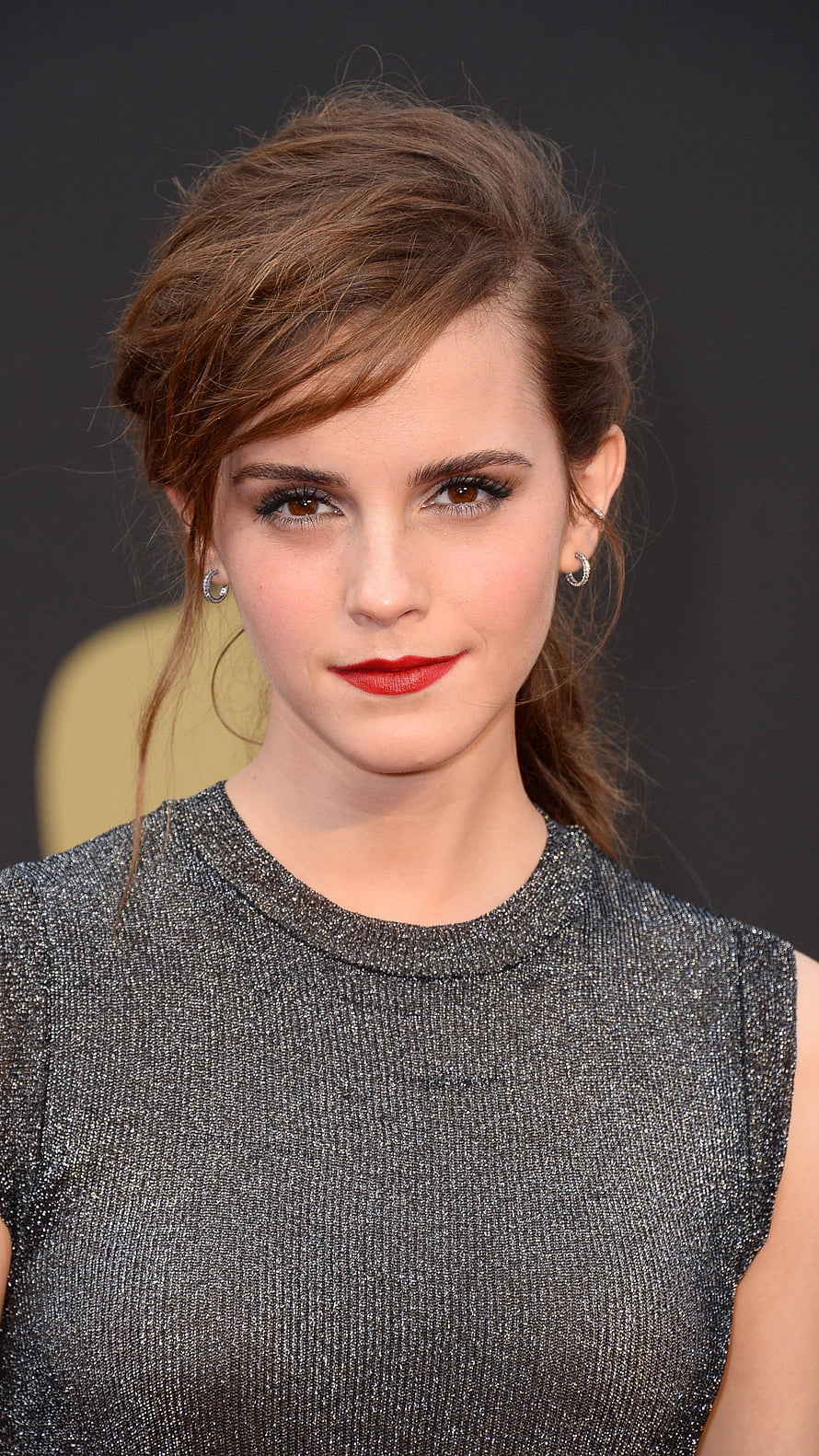 Emma Watson in a shimmering silver sleeveless top with elegant updo and red lipstick at a formal event HD phone wallpaper