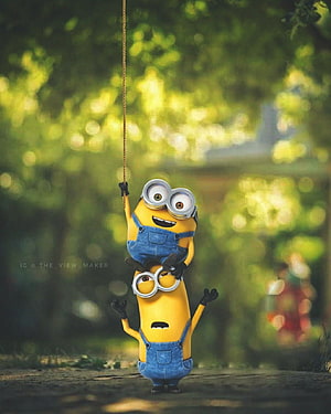 Two Minions Playing on a Rope Swing in a Sunlit Forest HD phone wallpaper
