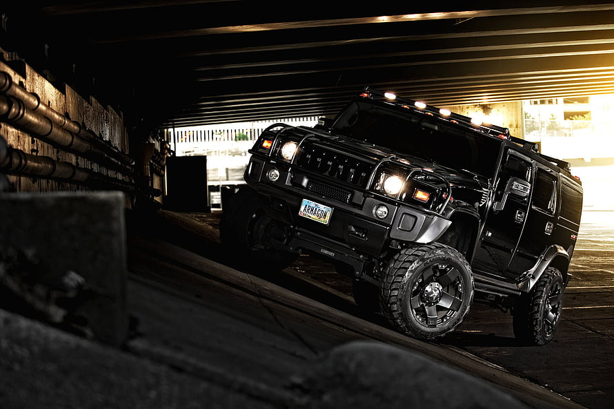 Black Hummer H2 SUV with Off-Road Tires Parked in a Dimly Lit Urban Underpass HD wallpaper