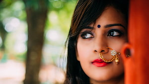 Close-up portrait of a young Indian woman wearing traditional gold nose ring and bindi HD wallpaper