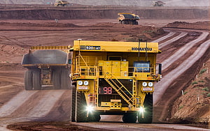 Komatsu 930E-AT Ultra-Class Mining Haul Truck Operating in Open Pit Iron Ore Quarry HD wallpaper