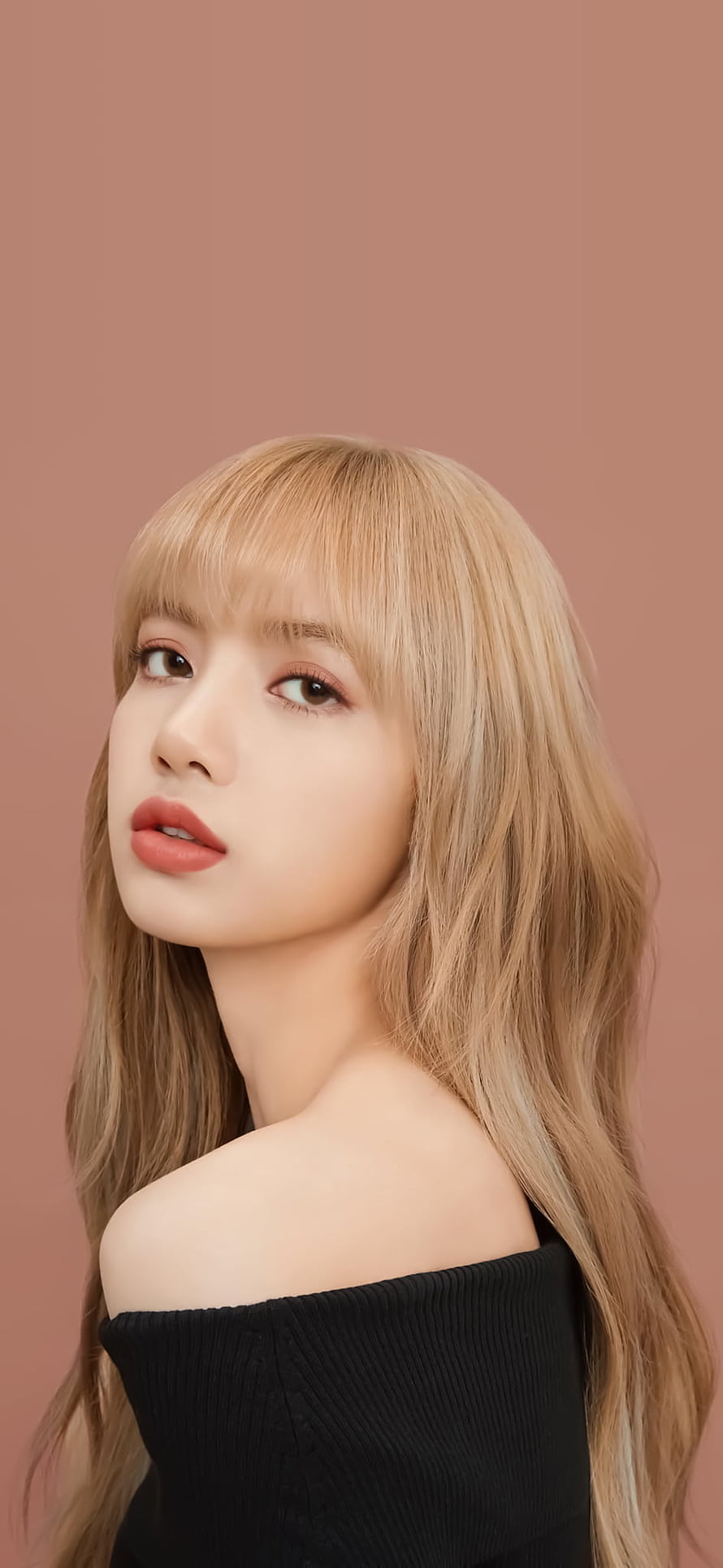 Lisa from Blackpink in a black off-shoulder top with blonde hair and bangs against a warm pink studio background HD phone wallpaper