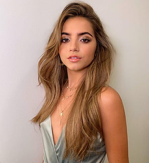 Isabela Merced in a Silver Satin Top with Layered Gold Necklaces and Wavy Hair HD phone wallpaper