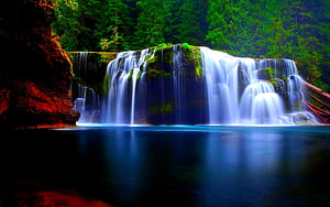 Serene Forest Waterfall Cascading Into a Deep Blue Pool Surrounded by Lush Greenery HD wallpaper