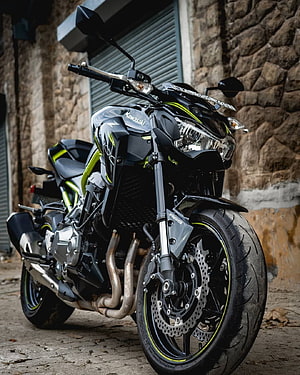 Kawasaki Z900 Black and Lime Green Street Bike Parked Against Stone Wall HD phone wallpaper
