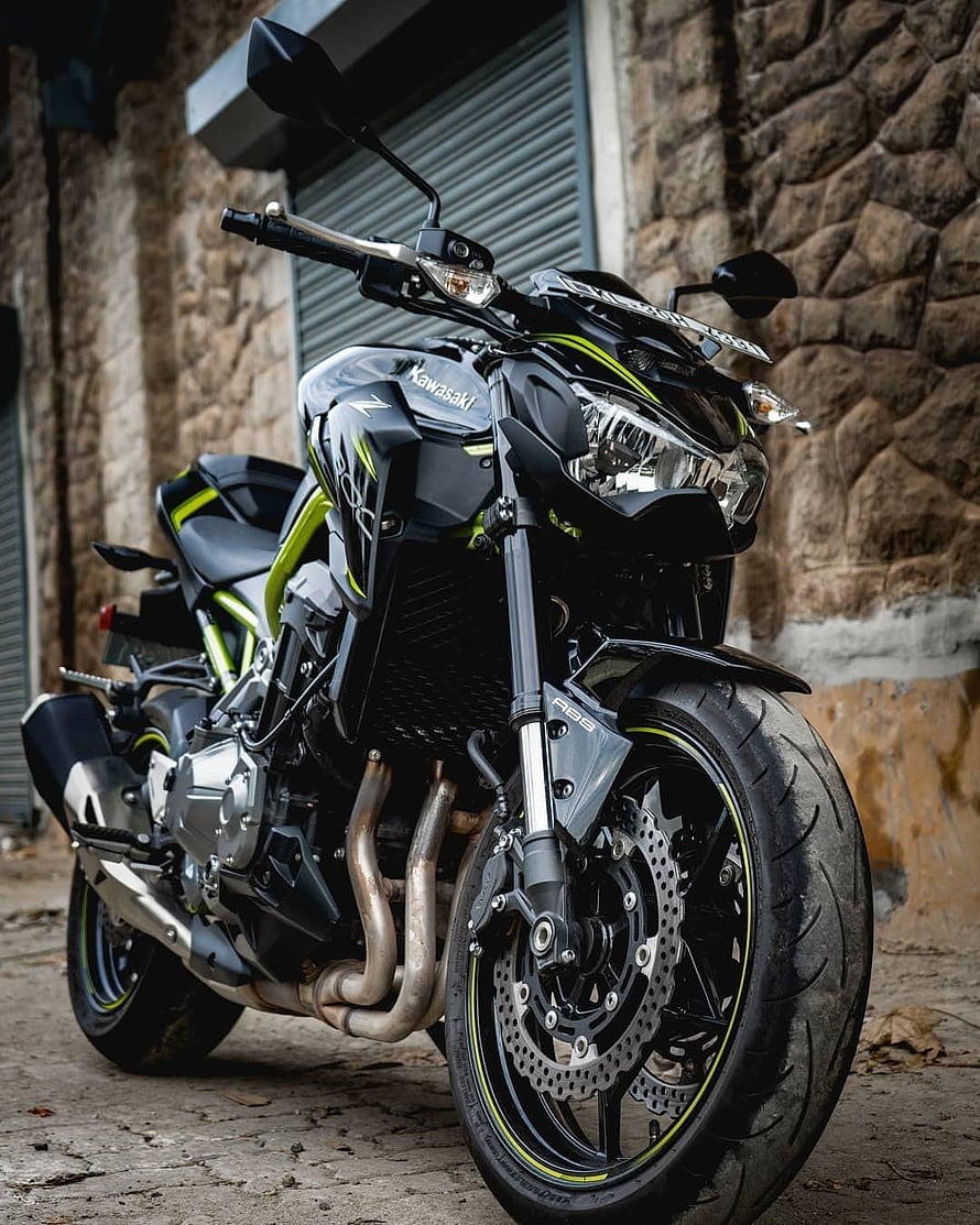 Kawasaki Z900 Black and Lime Green Street Bike Parked Against Stone Wall HD phone wallpaper