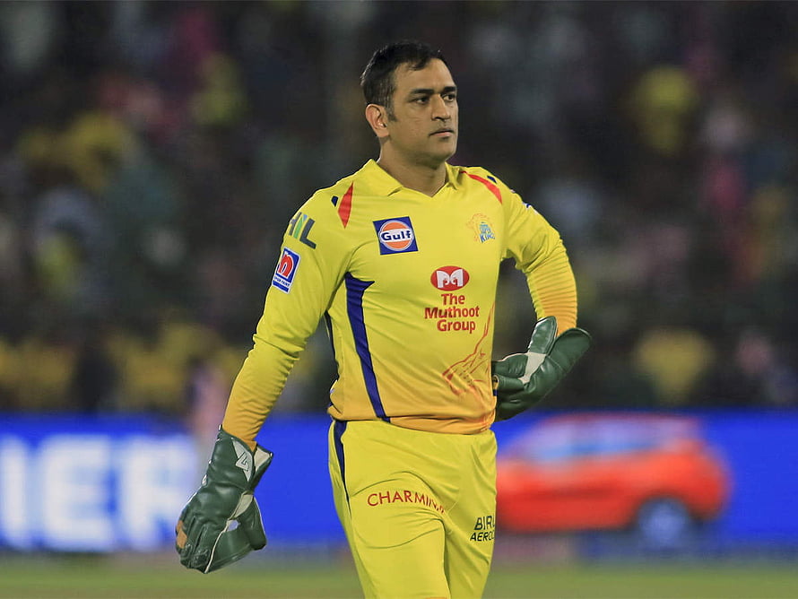 MS Dhoni in Chennai Super Kings yellow kit with green gloves on the cricket field HD wallpaper