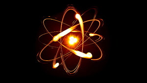 Glowing Atomic Structure with Orbiting Electrons and Radiant Core on Black Background HD wallpaper