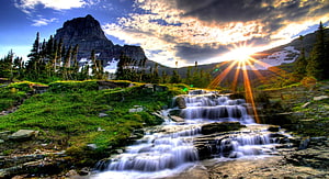 Sunburst Over Mountain Waterfall and Lush Green Valley at Sunset HD wallpaper