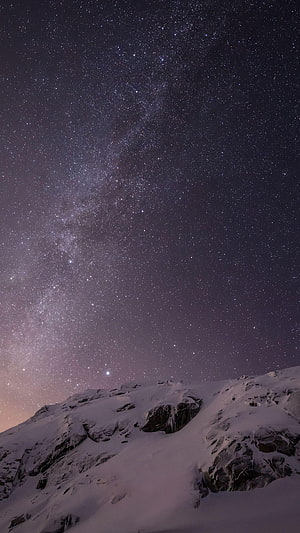 Milky Way Galaxy Arching Over Snow-Capped Mountain Ridge at Night HD phone wallpaper
