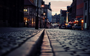 Cobblestone Street at Dusk with European Architecture and Warm Streetlights HD wallpaper