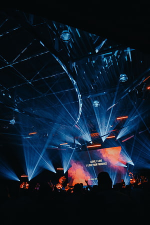 Vibrant Concert Stage With Blue Laser Beams And Silhouetted Crowd HD phone wallpaper