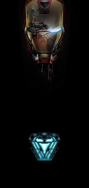 Damaged Iron Man Helmet with Glowing Arc Reactor on Black Background HD phone wallpaper