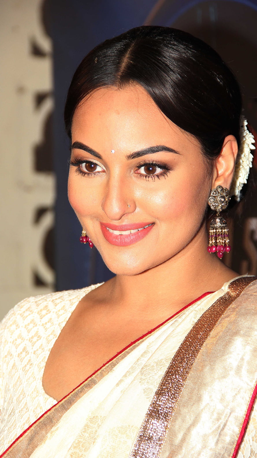 Sonakshi Sinha in an elegant cream saree with traditional jewelry and floral hair accessory HD phone wallpaper