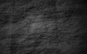 Dark Rough Stone Wall Texture with Subtle Lighting and Natural Surface Detail HD wallpaper