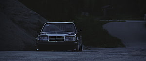 Black Mercedes-Benz W124 Sedan Parked on a Dark Gravel Road at Night HD wallpaper