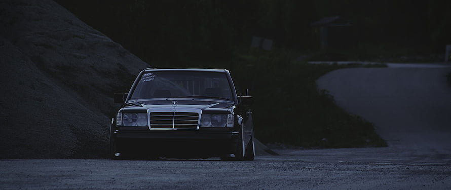 Black Mercedes-Benz W124 Sedan Parked on a Dark Gravel Road at Night HD wallpaper
