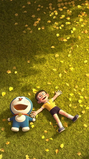 Doraemon and Nobita relaxing on a grassy field scattered with yellow autumn leaves HD phone wallpaper