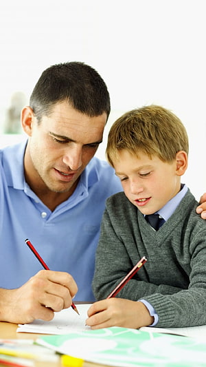 Father and son working together on a school project with pencils and paper HD phone wallpaper