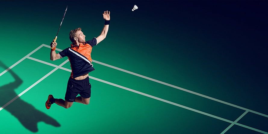 Badminton Player Leaping for a Smash on a Green Court HD wallpaper