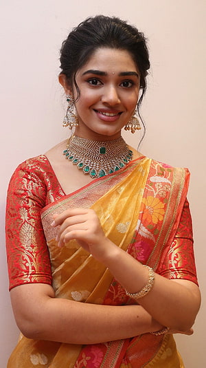 Krithi Shetty in Traditional Red and Gold Saree with Emerald Jewelry HD phone wallpaper