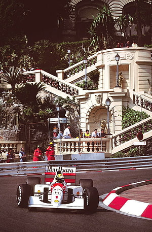Ayrton Senna in a Ferrari F1 car navigating the Monaco Grand Prix street circuit HD phone wallpaper