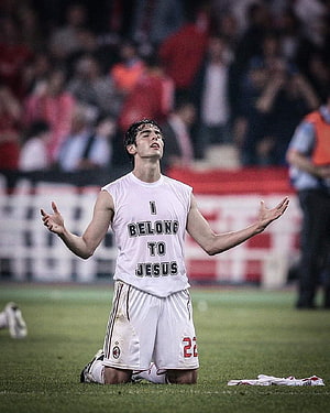 Kaka kneeling in prayer on the pitch wearing an AC Milan kit with I Belong To Jesus shirt HD phone wallpaper