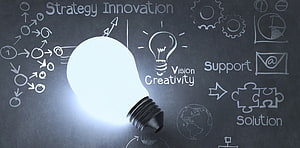 Glowing Light Bulb on Chalkboard with Business Strategy and Innovation Concepts HD wallpaper