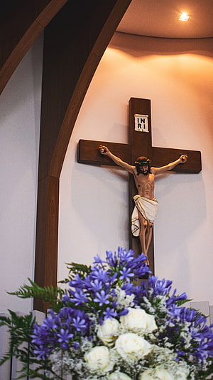 Wooden Crucifix with Jesus Christ and Floral Arrangement in Modern Church Interior HD phone wallpaper