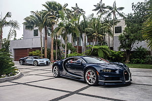 Two Bugatti Chiron Supercars Parked in a Tropical Luxury Estate Driveway HD wallpaper