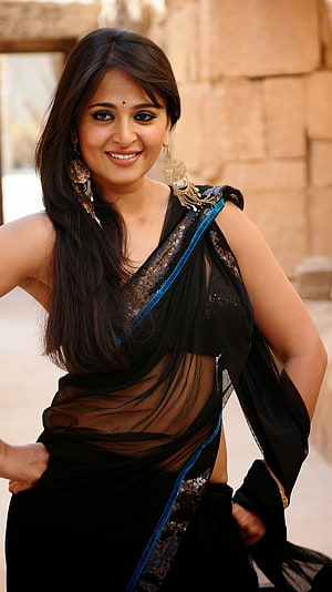 Anushka Shetty in a Black Sheer Saree with Blue Border and Gold Jewelry HD phone wallpaper