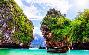 Traditional Longtail Boat Moored in Turquoise Waters of Thailand's Dramatic Limestone Caves HD wallpaper