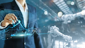 Businessman Interacting with Holographic Data Interface in Industrial Automation Facility HD wallpaper