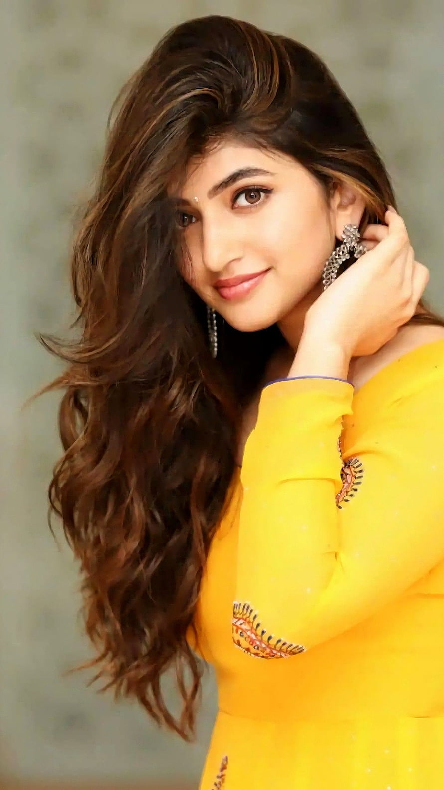 Sreeleela in a vibrant yellow embroidered kurta with long wavy hair and elegant earrings HD phone wallpaper