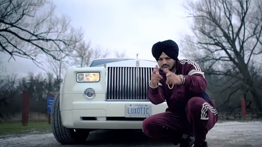Sidhu Moose Wala Crouching in Front of White Rolls Royce Ghost in Maroon Tracksuit HD wallpaper