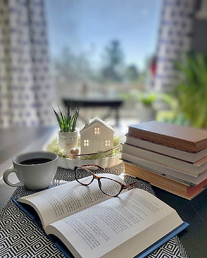 Cozy Reading Nook with Coffee, Glasses, and Stacked Books by a Sunny Window HD phone wallpaper