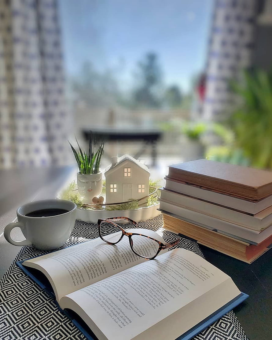 Cozy Reading Nook with Coffee, Glasses, and Stacked Books by a Sunny Window HD phone wallpaper