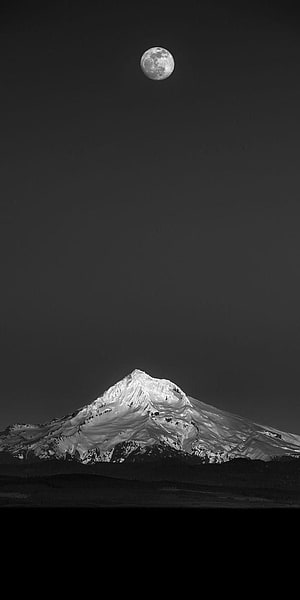 Monochrome Snow-Capped Mountain Peak Under a Full Moon in a Dark Night Sky HD phone wallpaper