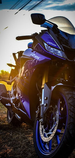 Yamaha R15 sport motorcycle parked in golden hour sunlight with dramatic sky backdrop HD phone wallpaper