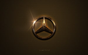 Mercedes-Benz Golden Emblem on Textured Brown Metal Surface with Dramatic Lens Flare HD wallpaper