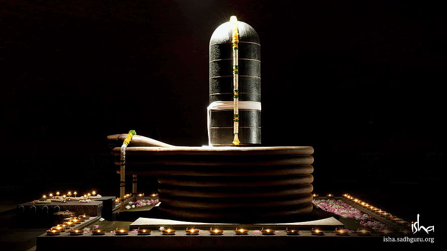 Isha Dhyanalinga Sacred Stone Sculpture Illuminated by Candles and Floral Offerings HD wallpaper