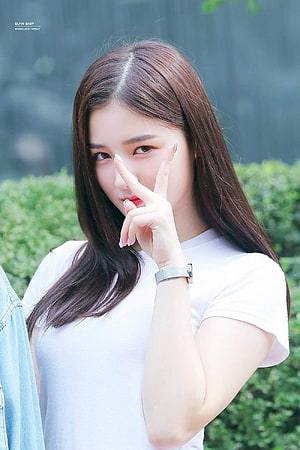 Nancy from Momoland in a white t-shirt making a peace sign outdoors HD phone wallpaper