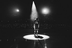 Kobe Bryant Standing Alone in a Spotlight on a Basketball Court HD wallpaper
