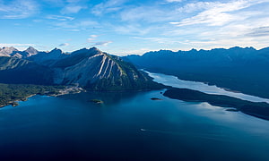 Aerial View of a Serene Mountain Lake with Forested Islands and Rugged Peaks HD wallpaper