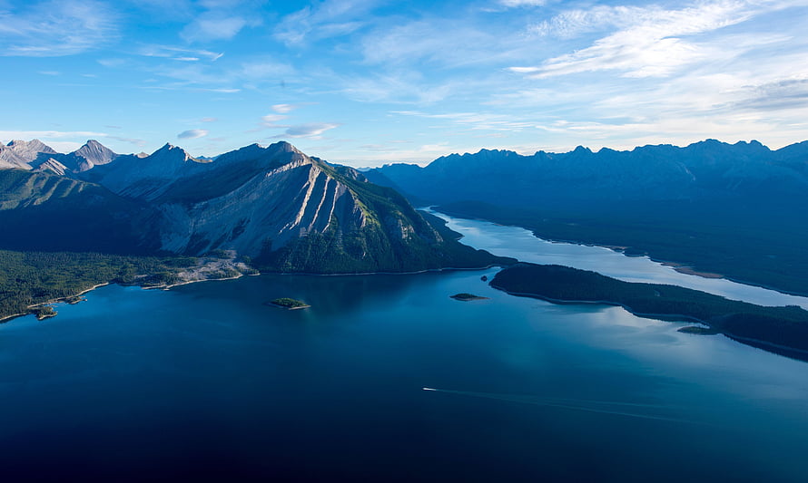 Aerial View of a Serene Mountain Lake with Forested Islands and Rugged Peaks HD wallpaper
