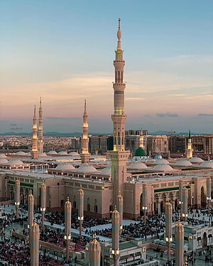 Nabawi Mosque in Medina at Dusk with Illuminated Minarets and Crowded Courtyard HD phone wallpaper